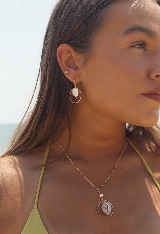 holding pearl earrings